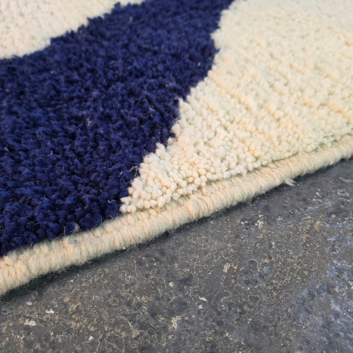 Close-up of thick navy and cream wool pile on the abstract Azilal rug