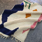 Abstract Azilal rug folded in soft waves showing navy, pink and orange shapes