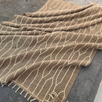 Taupe and ivory kilim rug folded in soft waves