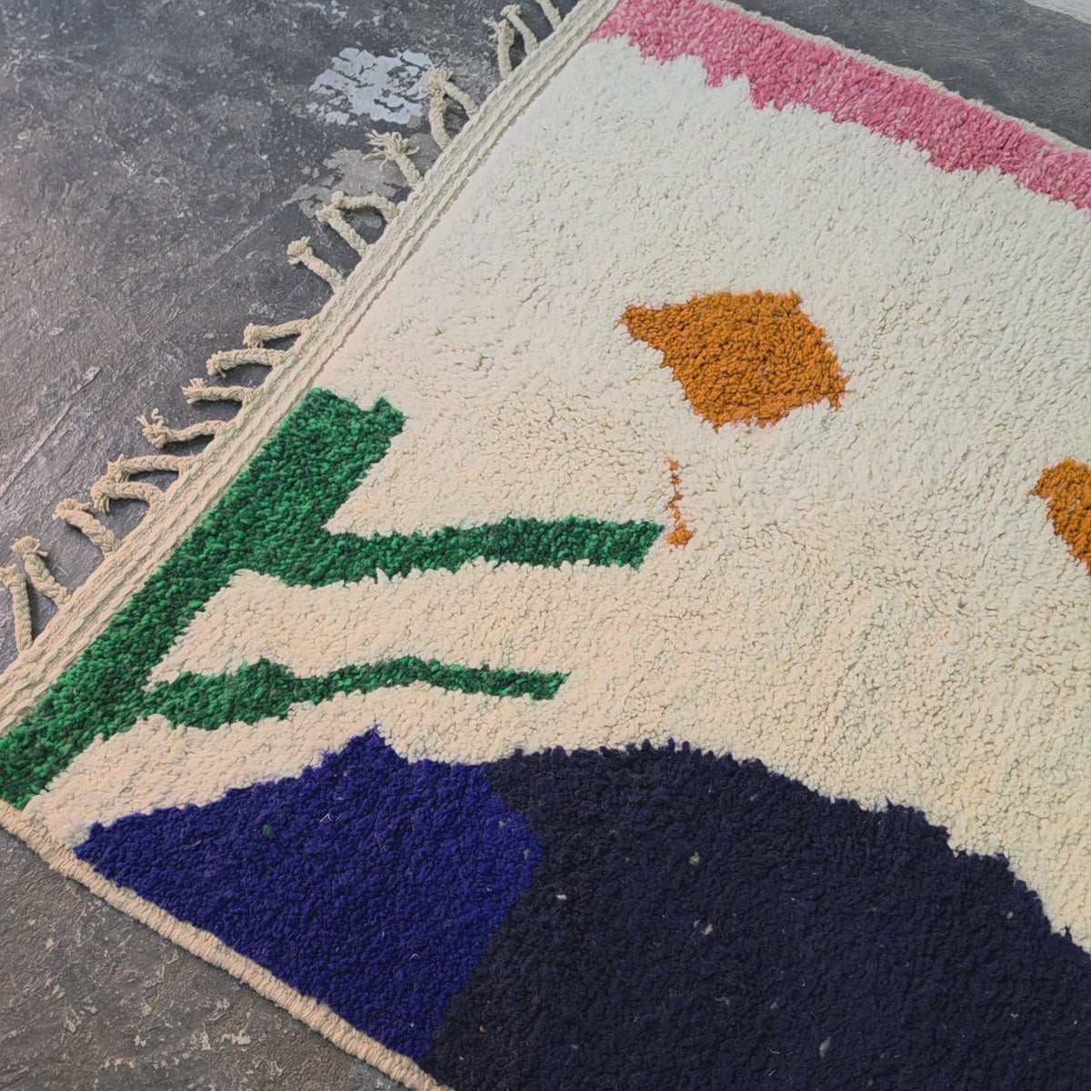 Video of the abstract cream Azilal rug with navy, pink, green and orange shapes, shown up close