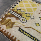 Video of the hand-knotted Moroccan Berber rug with brown and mustard tribal symbols, shown up close