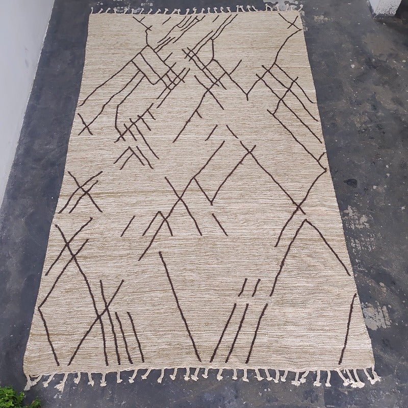 Moroccan Kilim flat-weave rug laid flat, top-down view of geometric line design and hand-tied fringe