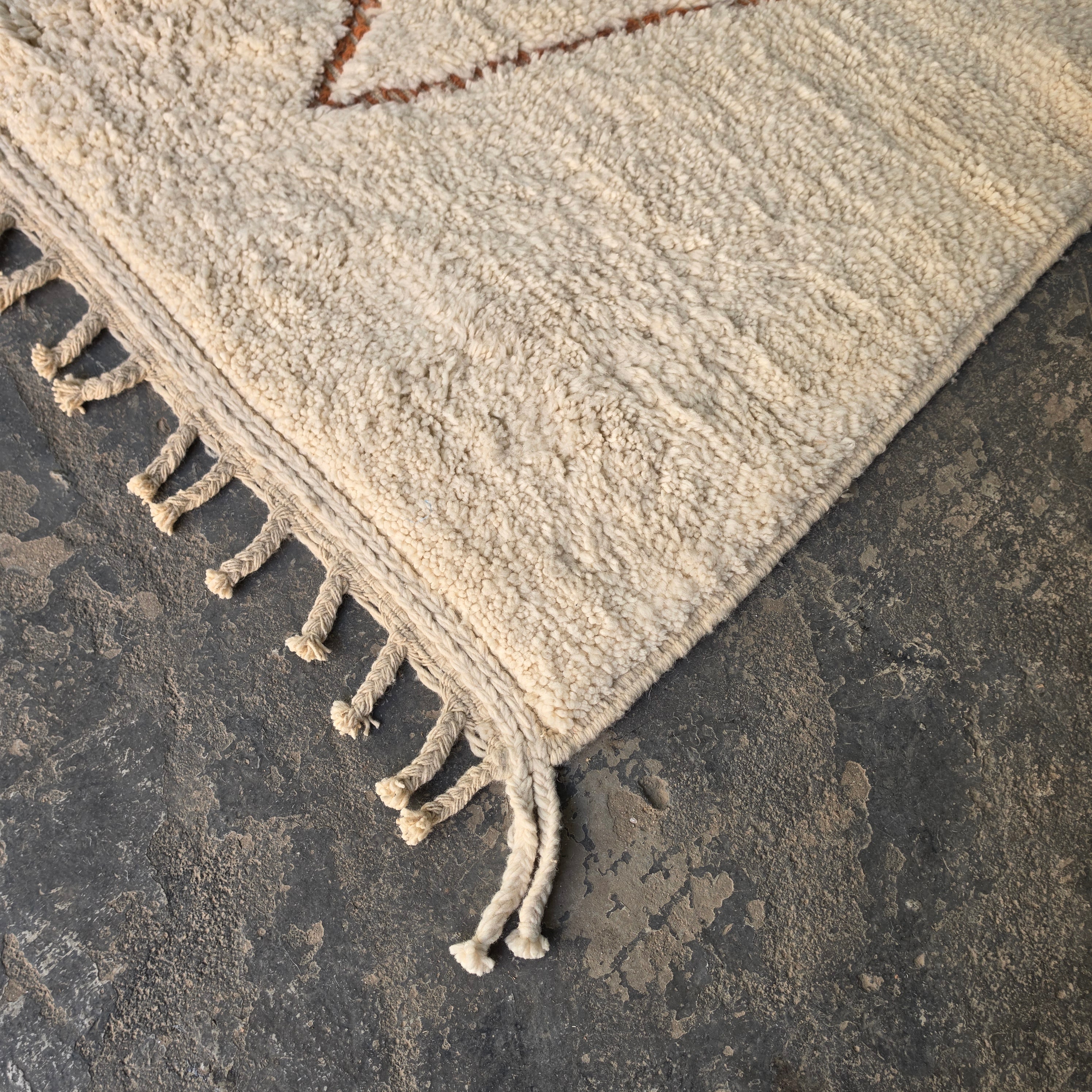 Close-up of hand-knotted fringe tassels on a Moroccan Berber wool rug