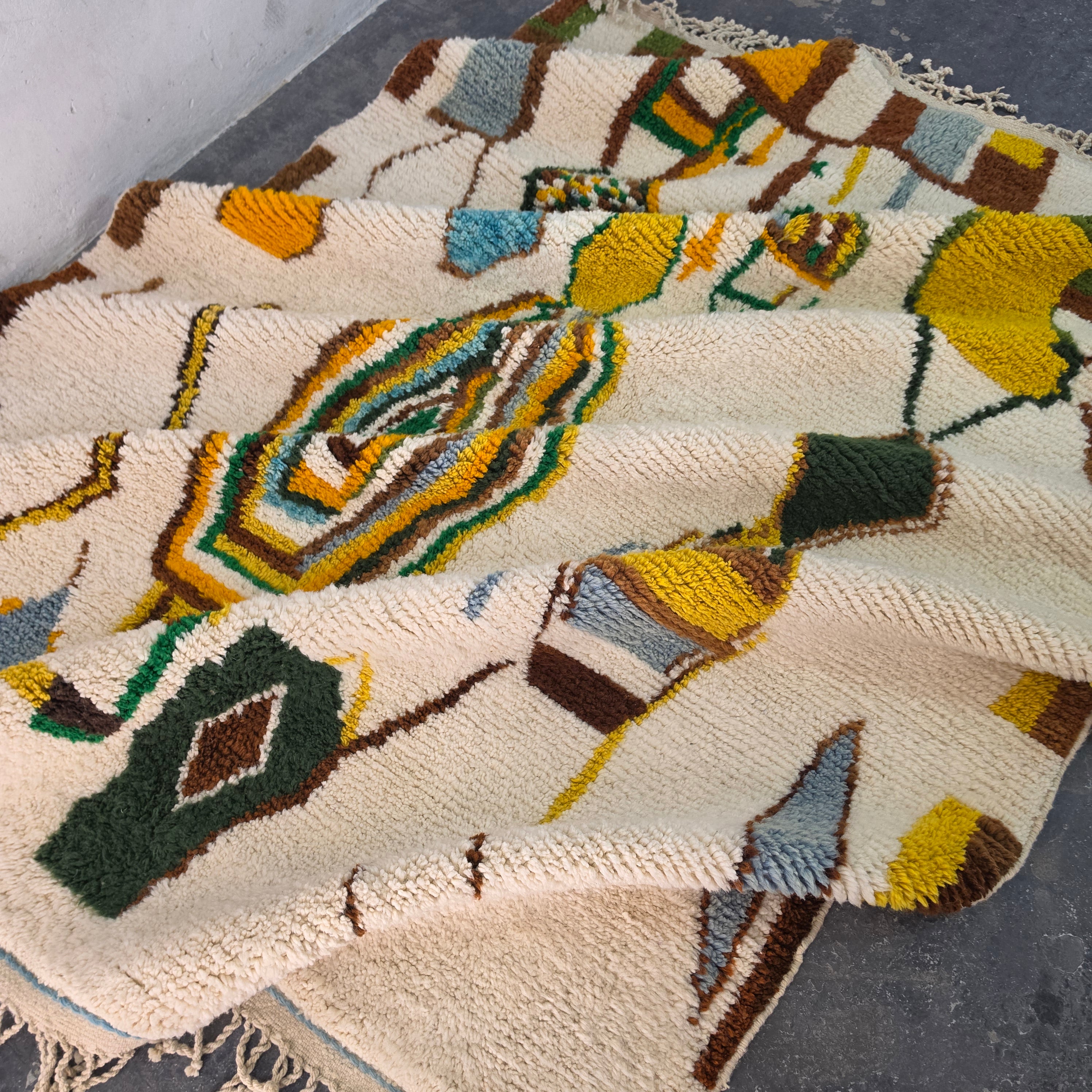 Moroccan Boujad rug folded in soft waves showing colorful abstract tribal pattern