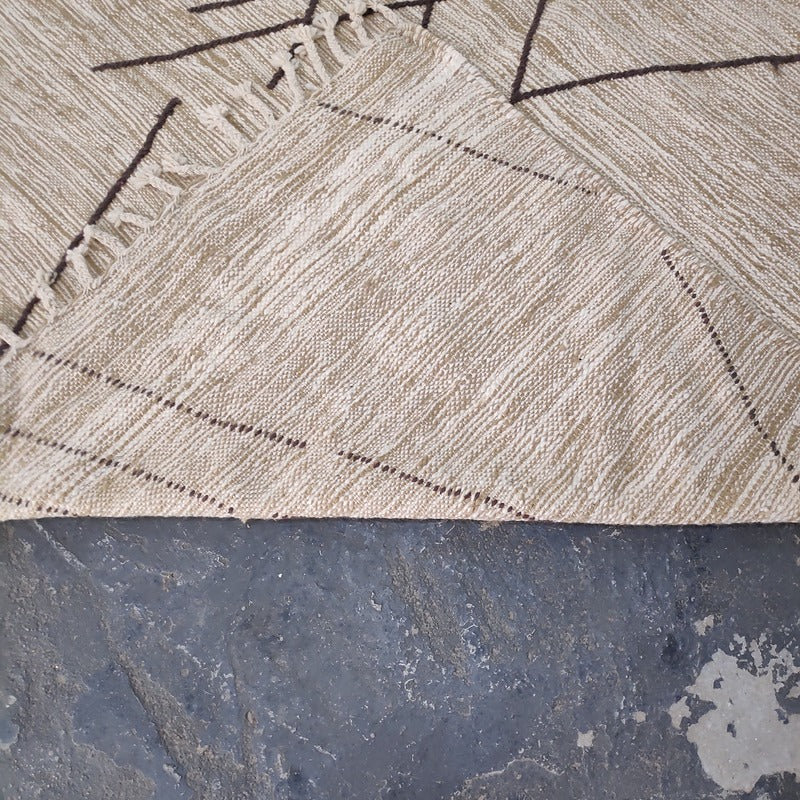 Folded corner of Moroccan Kilim rug showing wool weave and geometric stitching detail