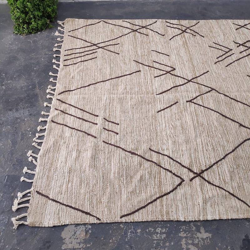 Close angled view of Moroccan Kilim rug corner with hand-knotted fringe and beige wool weave