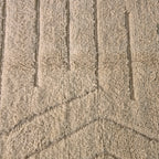 Close-up of carved chevron and line relief in the ivory wool pile