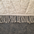 Close-up of the hand-tied fringe along the edge of the oversized Beni Ourain rug