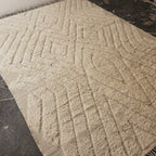 Angled view of the oversized ivory Beni Ourain rug showing the full carved relief pattern