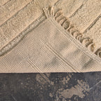 Folded corner of the modern boho rug showing the woven reverse side