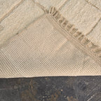 Folded corner of the ivory Beni Ourain rug showing the woven reverse side