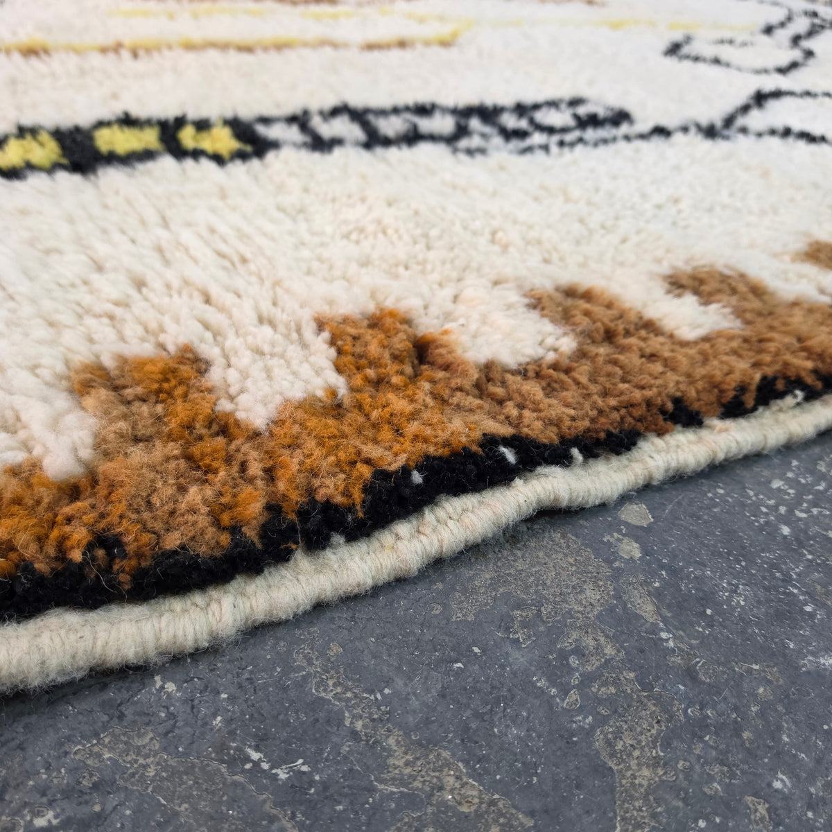 Close-up of brown and rust wool pile texture on a Moroccan Berber rug corner