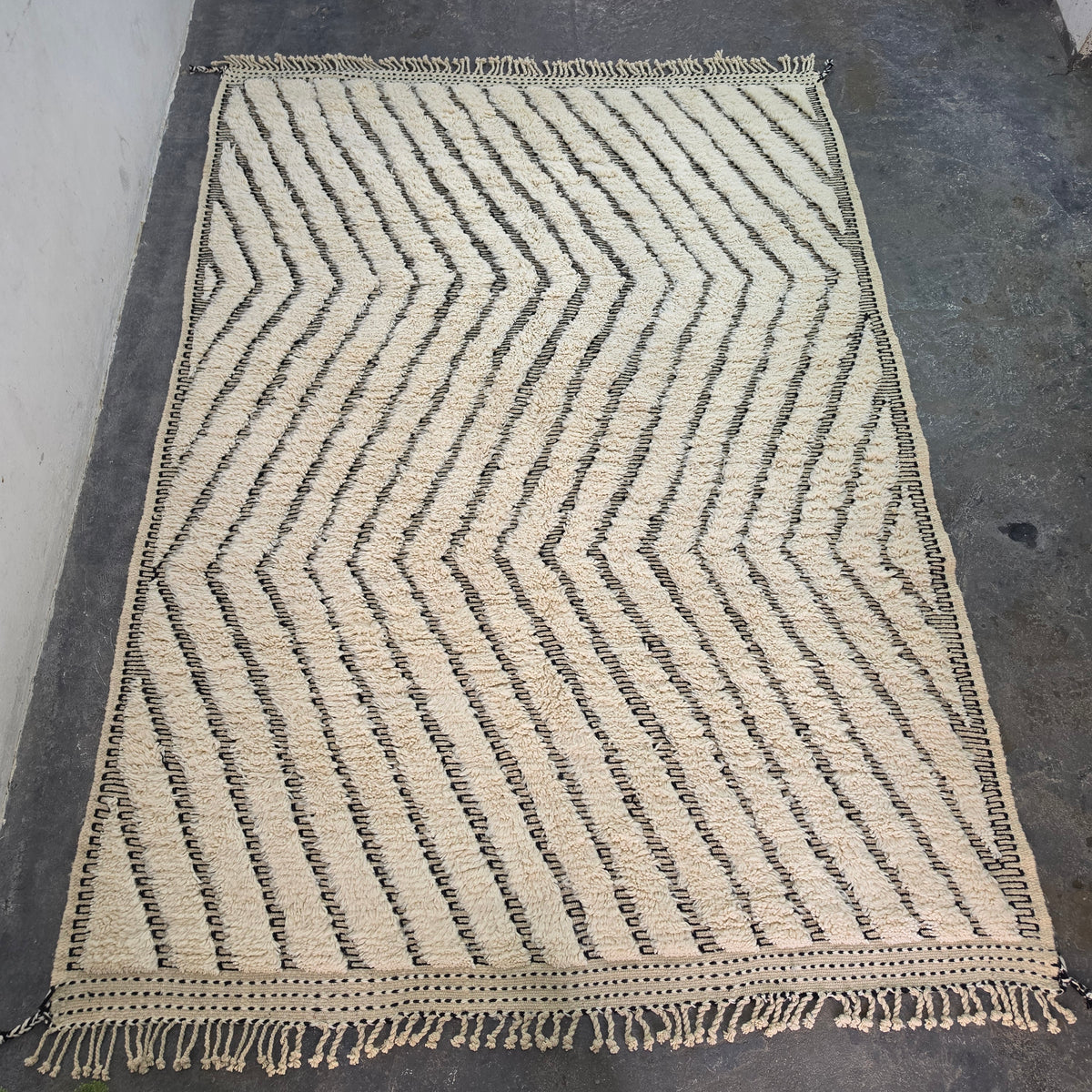 Moroccan Beni Ourain rug laid flat, full top-down view of wavy chevron pattern in ivory wool