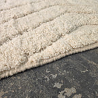Close-up of thick ivory wool pile with carved lines on the modern boho rug