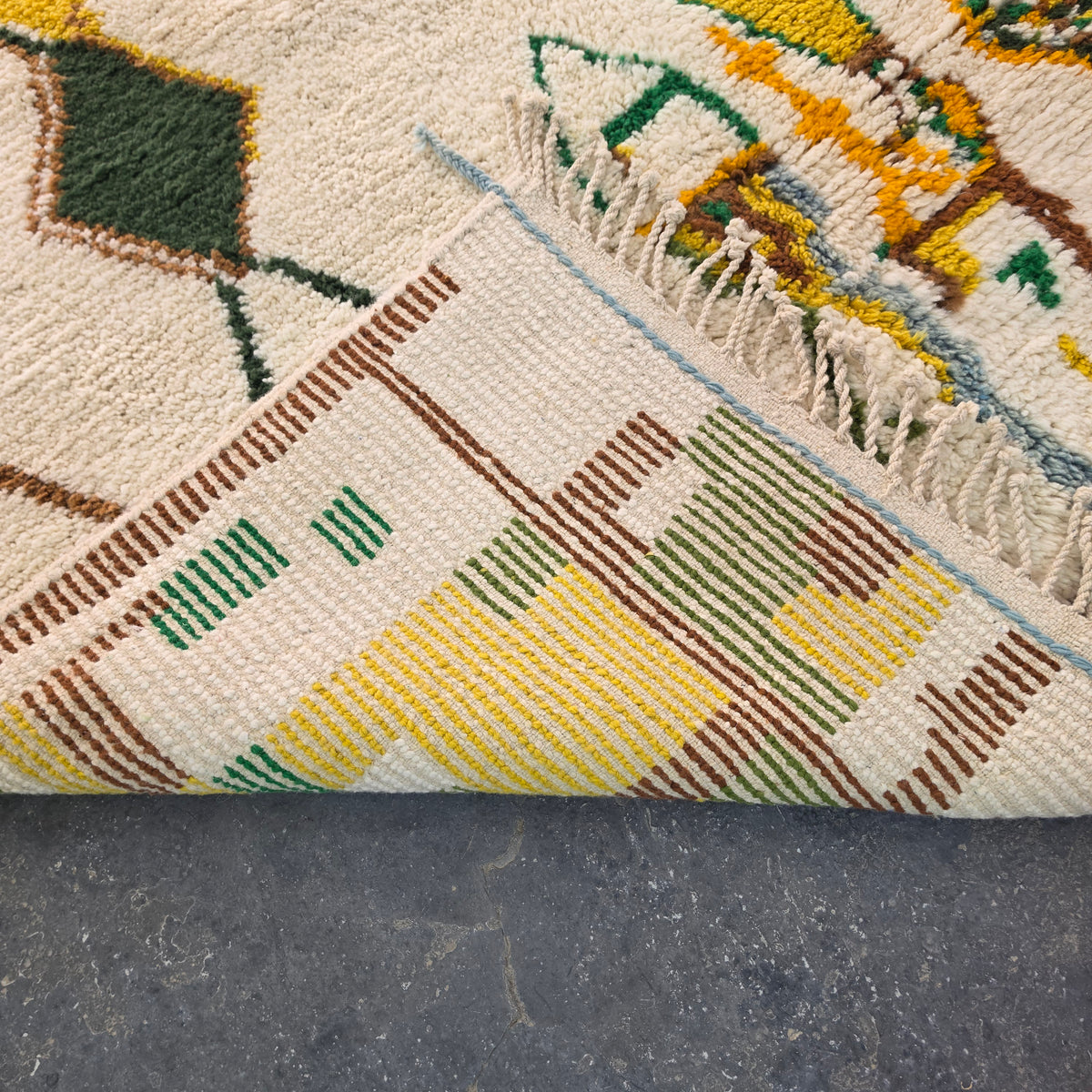 Folded corner of Moroccan Boujad rug showing the woven flat-weave pattern on the reverse side