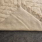 Folded corner of the oversized Beni Ourain rug showing the woven reverse side