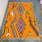 Vibrant orange Moroccan Boujad rug laid flat, full top-down view of colorful diamond pattern
