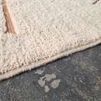 Close-up of thick cream wool pile texture on a Moroccan Berber rug