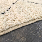 Close-up of thick ivory wool pile with a black diamond line on the Beni Ourain rug