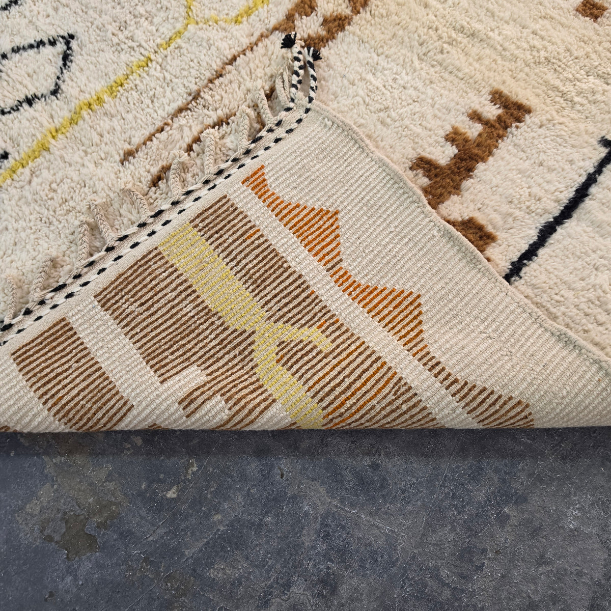 Folded corner of Moroccan Berber rug showing the woven flat-weave pattern on the reverse side