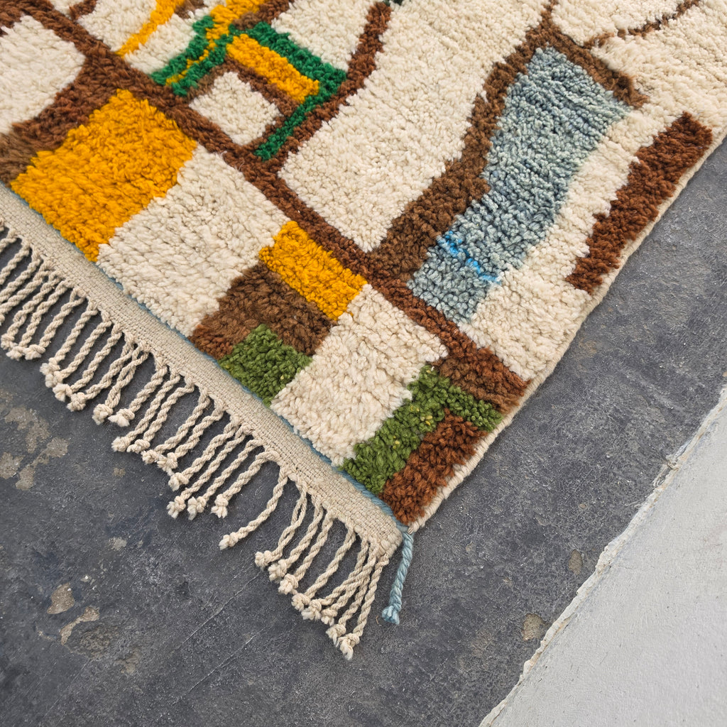 Close-up corner of Moroccan Boujad rug showing mustard, green, and brown wool tufting